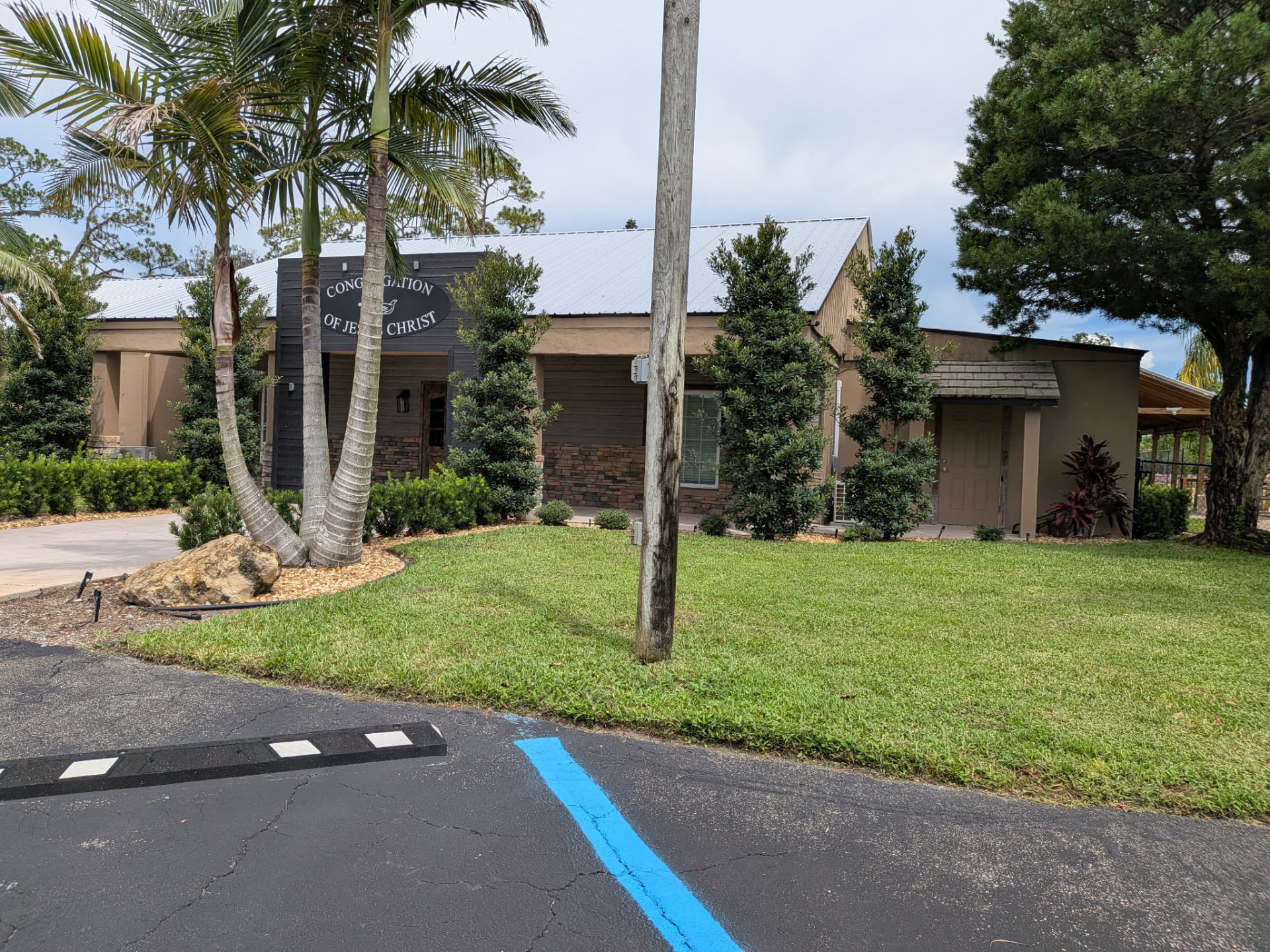 Landscaped commercial property with palm trees, manicured lawn, and maintained beds in Okeechobee, Florida
